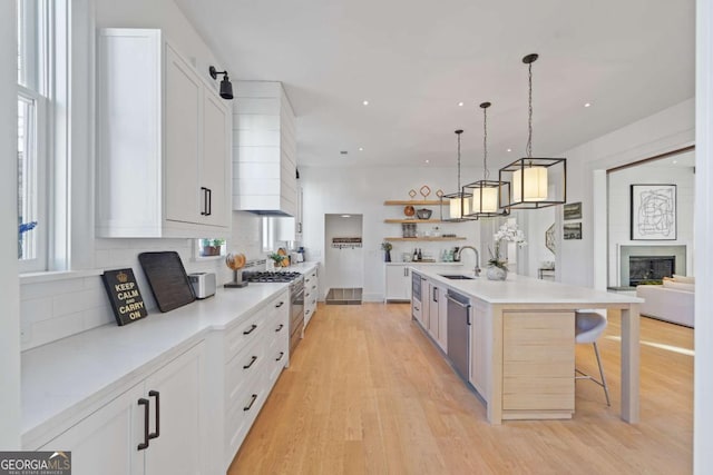 kitchen featuring a kitchen breakfast bar, white cabinetry, and an island with sink