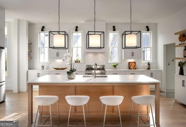 kitchen featuring tasteful backsplash, light countertops, and a sink