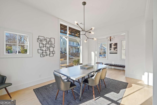 dining area with a chandelier and light hardwood / wood-style flooring