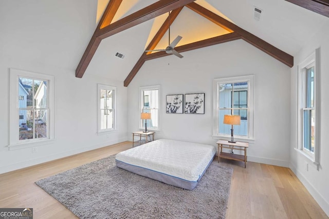 bedroom with ceiling fan, light hardwood / wood-style flooring, high vaulted ceiling, and beamed ceiling