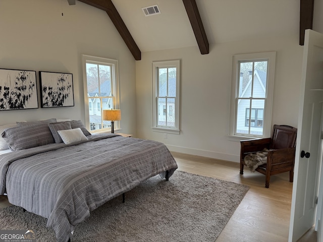 bedroom featuring lofted ceiling with beams, light wood-style flooring, visible vents, and baseboards