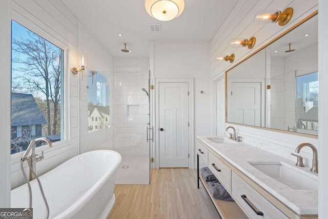 bathroom with hardwood / wood-style floors, vanity, and independent shower and bath