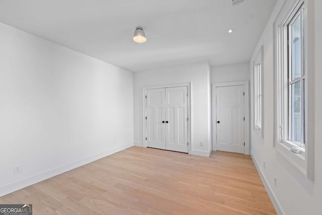 unfurnished bedroom featuring light wood finished floors and baseboards