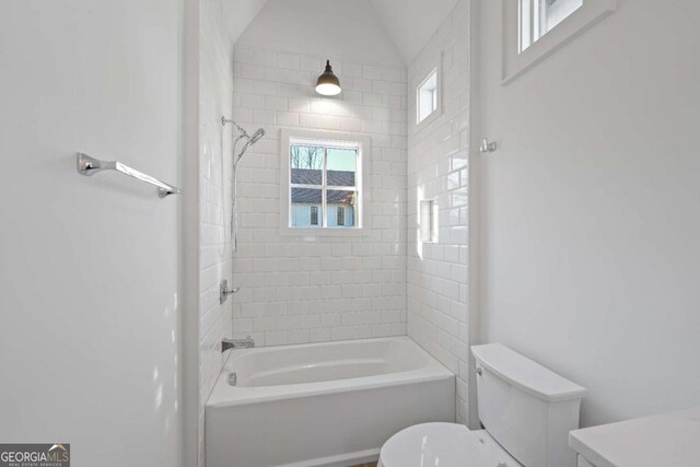 full bathroom featuring toilet, tiled shower / bath, and vanity