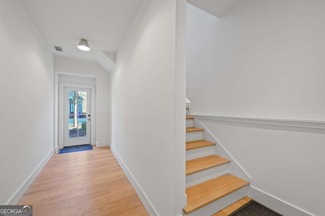 entryway featuring stairway, wood finished floors, visible vents, and baseboards