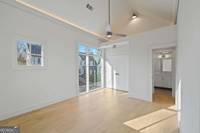 unfurnished bedroom with visible vents, baseboards, ceiling fan, wood finished floors, and vaulted ceiling