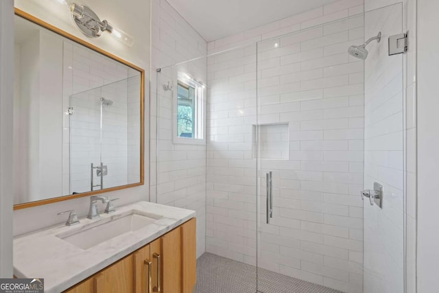 bathroom with a shower with shower door and vanity