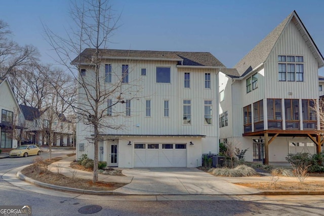 view of front of house featuring board and batten siding, a shingled roof, cooling unit, and concrete driveway