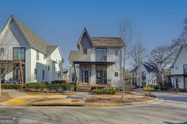 multi unit property with a shingled roof, board and batten siding, and a residential view