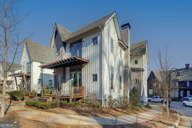 view of front of home featuring a chimney, board and batten siding, and roof with shingles