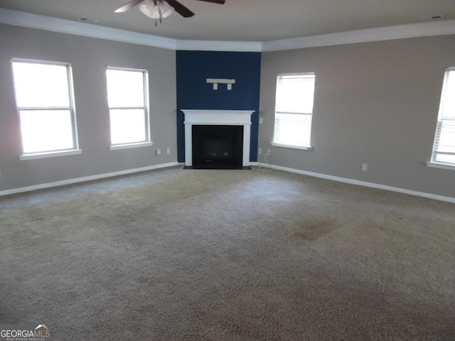 unfurnished living room featuring plenty of natural light, carpet, and ornamental molding