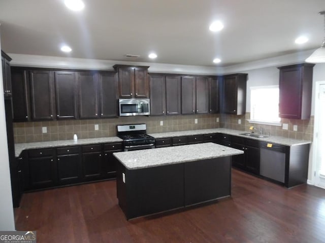 kitchen with dark wood-type flooring, sink, a center island, and stainless steel appliances