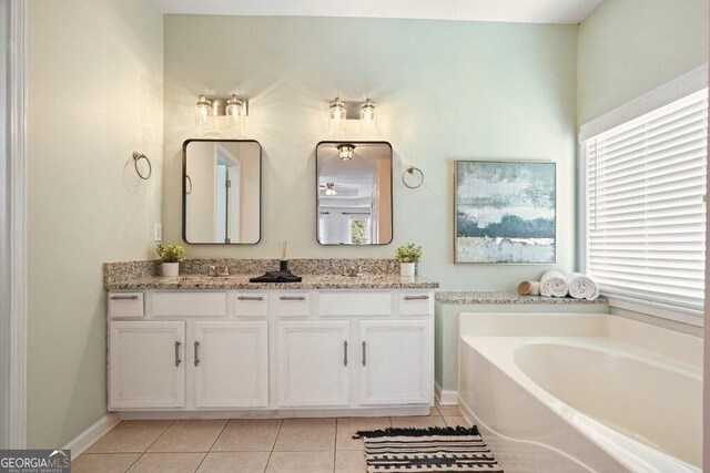 bathroom with a bathing tub, tile patterned floors, and vanity