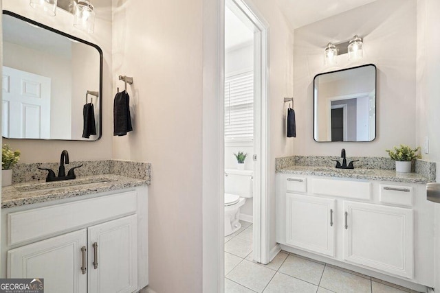 bathroom featuring toilet, vanity, and tile patterned flooring