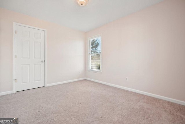 unfurnished room featuring light colored carpet