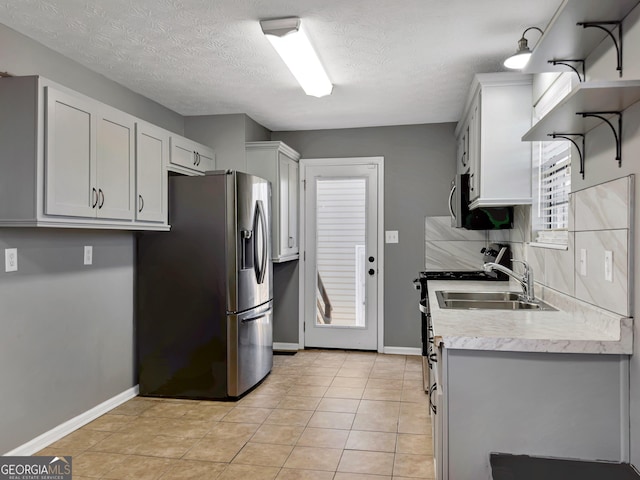 kitchen with white cabinets, sink, stainless steel fridge with ice dispenser, and light tile patterned floors