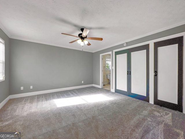 carpeted spare room featuring ceiling fan, french doors, a wealth of natural light, and a textured ceiling