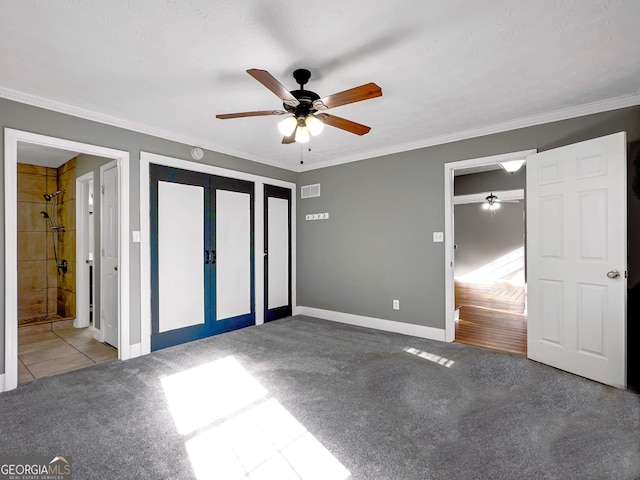 unfurnished bedroom with ceiling fan, ensuite bath, carpet flooring, ornamental molding, and french doors