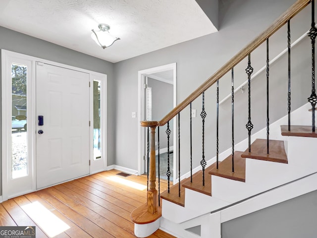 entryway featuring hardwood / wood-style floors and a textured ceiling