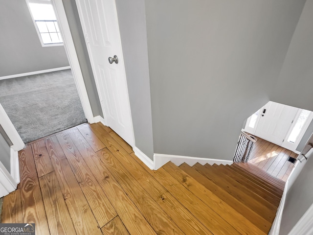 stairs featuring hardwood / wood-style floors