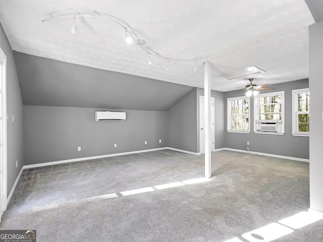 additional living space featuring carpet, a wall mounted AC, vaulted ceiling, cooling unit, and a textured ceiling