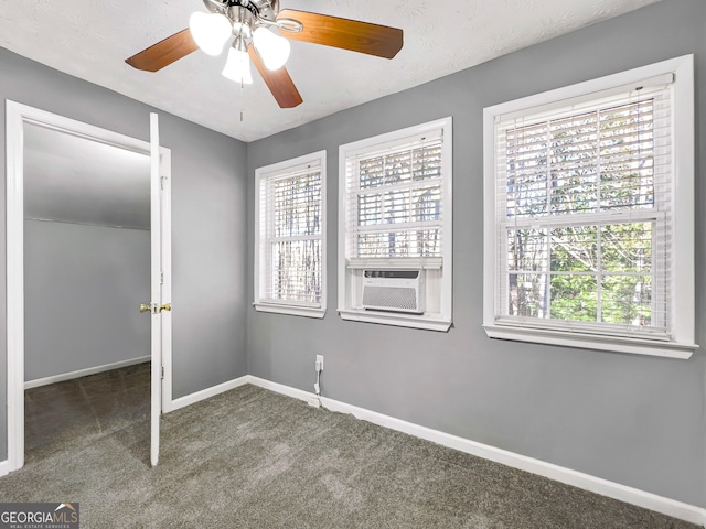 unfurnished bedroom with carpet, multiple windows, cooling unit, and ceiling fan