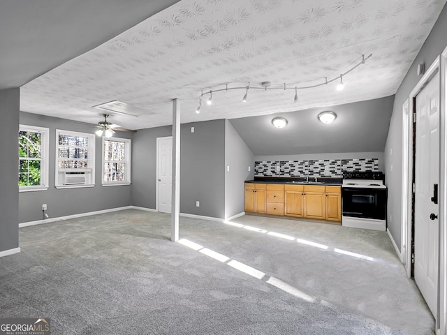 basement featuring ceiling fan, cooling unit, light colored carpet, a textured ceiling, and sink