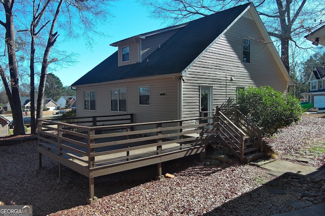 rear view of property featuring a wooden deck