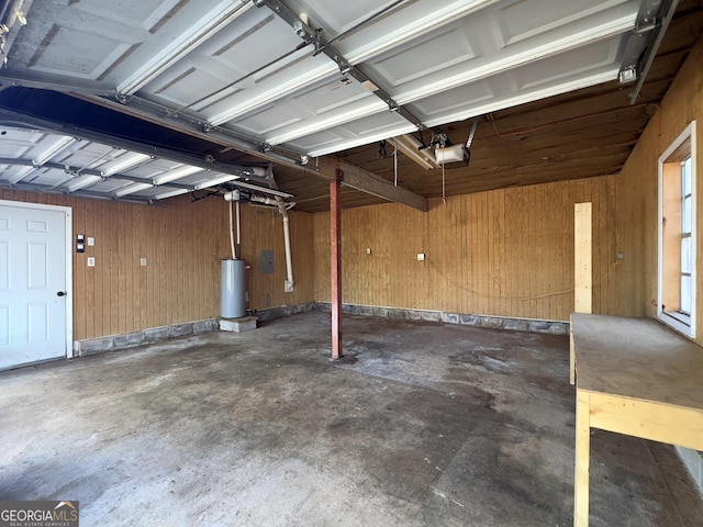 garage featuring water heater, a garage door opener, and wooden walls