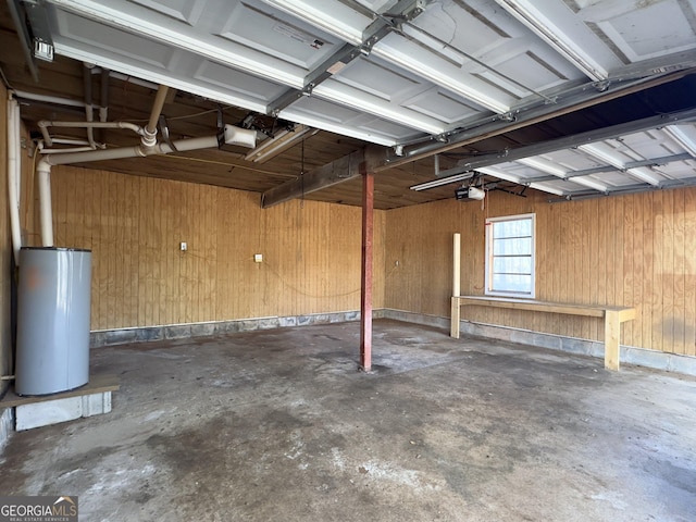 garage featuring a garage door opener, wooden walls, and gas water heater