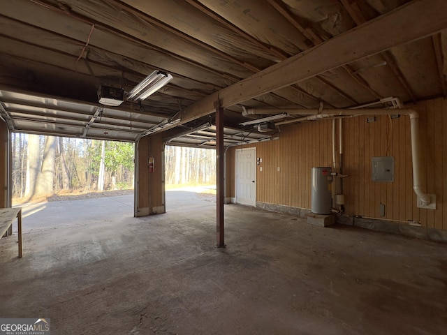 garage with water heater, a garage door opener, electric panel, and wood walls