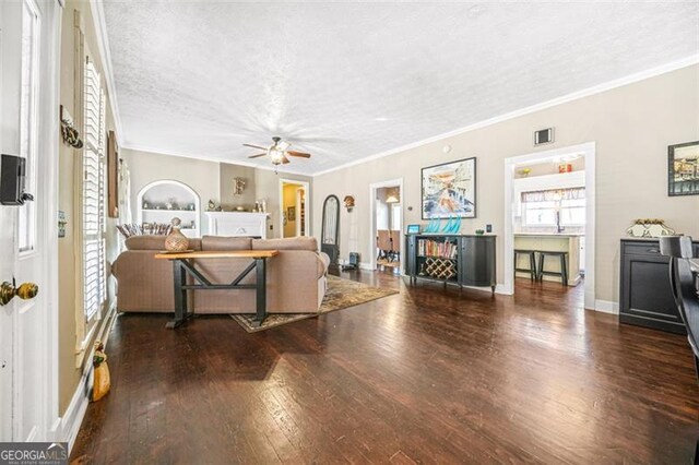 dining room featuring crown molding, dark hardwood / wood-style floors, ceiling fan, and a textured ceiling