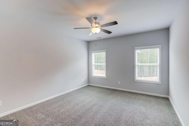 spare room featuring ceiling fan, plenty of natural light, and carpet flooring