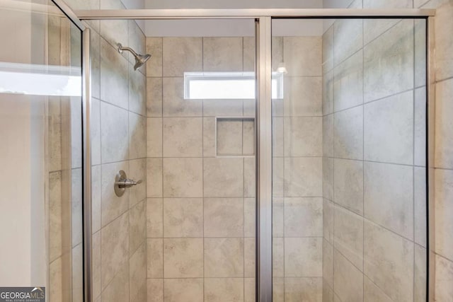 bathroom featuring a shower with shower door