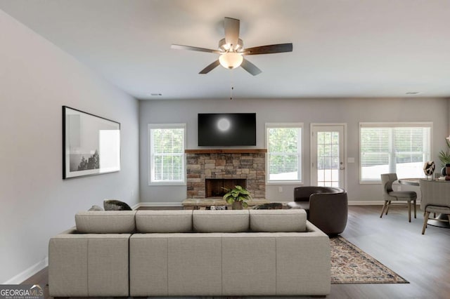 living room featuring ceiling fan, a fireplace, and hardwood / wood-style flooring