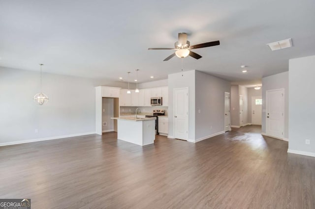 unfurnished living room featuring dark wood-type flooring, sink, and ceiling fan with notable chandelier