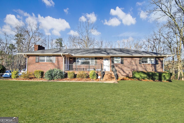 ranch-style home with covered porch, brick siding, a chimney, and a front yard