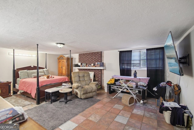 bedroom featuring a brick fireplace and a textured ceiling