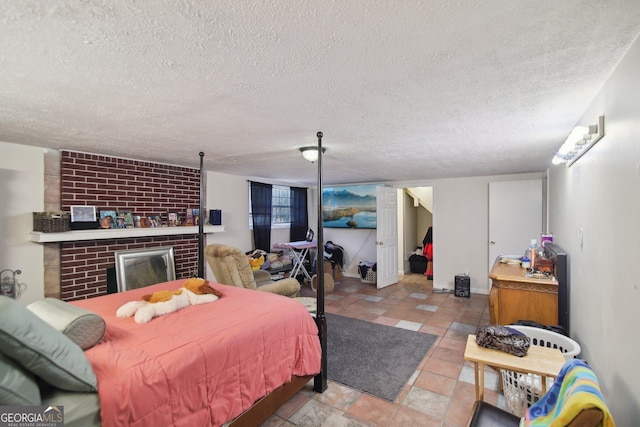 bedroom with a brick fireplace and a textured ceiling