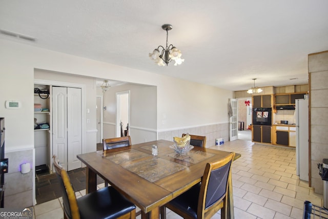 dining room with light tile patterned floors and an inviting chandelier