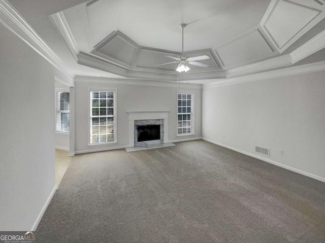 unfurnished living room featuring coffered ceiling, ceiling fan, carpet floors, a high end fireplace, and crown molding