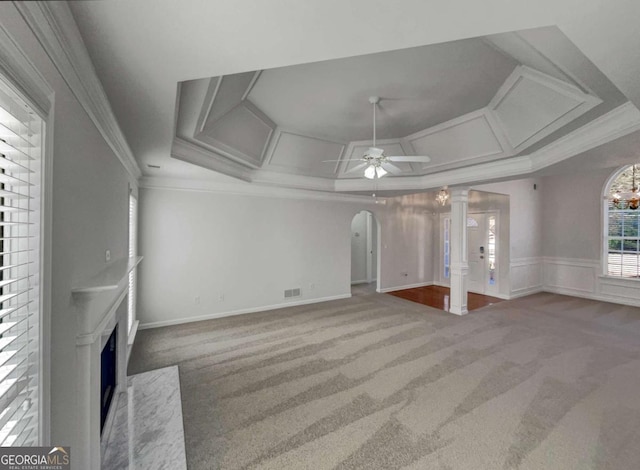 unfurnished living room featuring coffered ceiling, ceiling fan, carpet, a high end fireplace, and crown molding