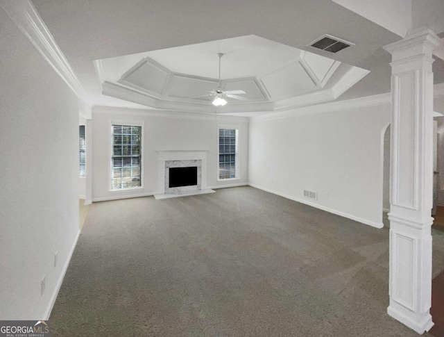 unfurnished living room featuring ceiling fan, a fireplace, crown molding, carpet flooring, and decorative columns