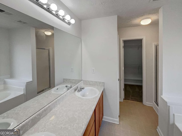 bathroom with a textured ceiling, independent shower and bath, and vanity