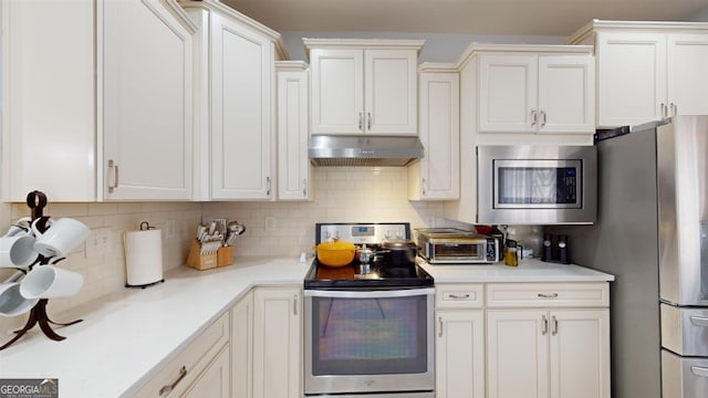 kitchen featuring white cabinets, stainless steel appliances, and tasteful backsplash