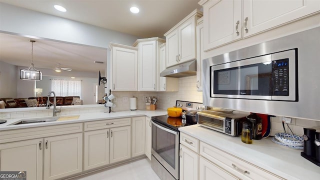 kitchen with white cabinets, backsplash, appliances with stainless steel finishes, and sink