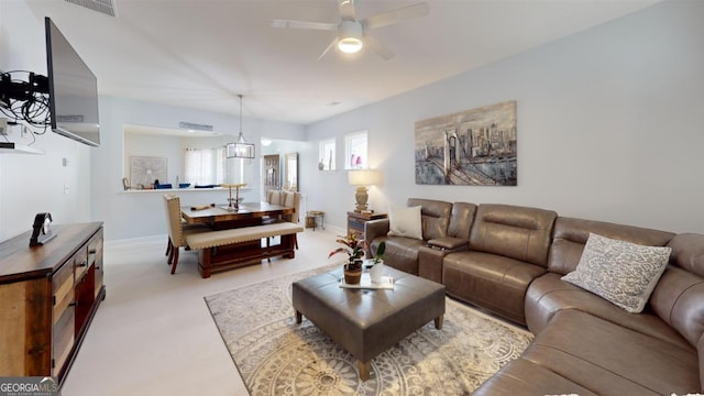 living room featuring ceiling fan with notable chandelier