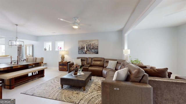 living room with ceiling fan with notable chandelier