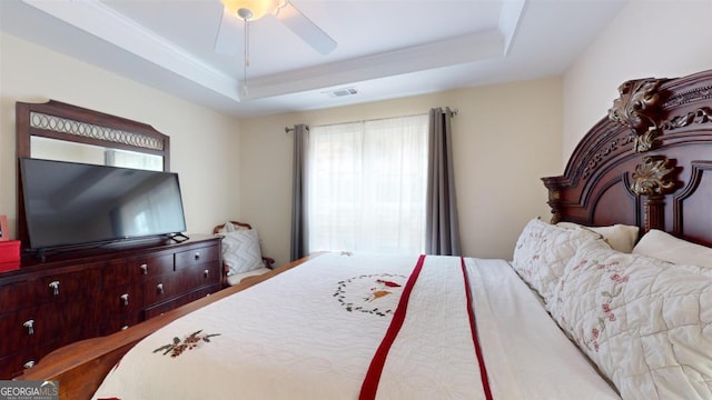 bedroom with ceiling fan, ornamental molding, and a raised ceiling