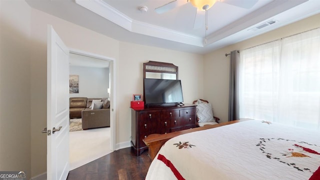 bedroom with ceiling fan, dark hardwood / wood-style flooring, crown molding, and a raised ceiling